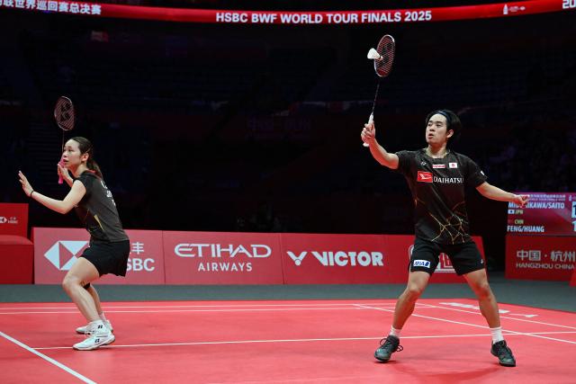 Japan’s Hiroki Midorikawa (R) and Natsu Saito play a point against China’s Feng Yanzhe and Huang Dongping during their mixed doubles semi-final match at the BWF Badminton World Tour Finals at the Hangzhou Olympic Sports Centre Gymnasium in Hangzhou, in eastern China's Zhejiang province on December 20, 2025. (Photo by Jade Gao / AFP)