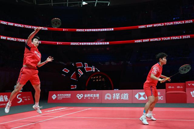 China’s Feng Yanzhe and Huang Dongping (R) play a point against Japan’s Hiroki Midorikawa and Natsu Saito during their mixed doubles semi-final match at the BWF Badminton World Tour Finals at the Hangzhou Olympic Sports Centre Gymnasium in Hangzhou, in eastern China's Zhejiang province on December 20, 2025. (Photo by Jade Gao / AFP)
