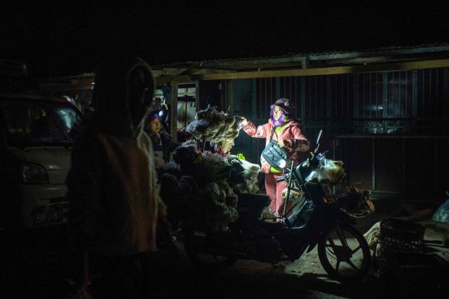 This photo taken on December 20, 2025 shows a vendor waiting for customers at a market area in Lashio in Myanmar's northern Shan state. (Photo by AFP)