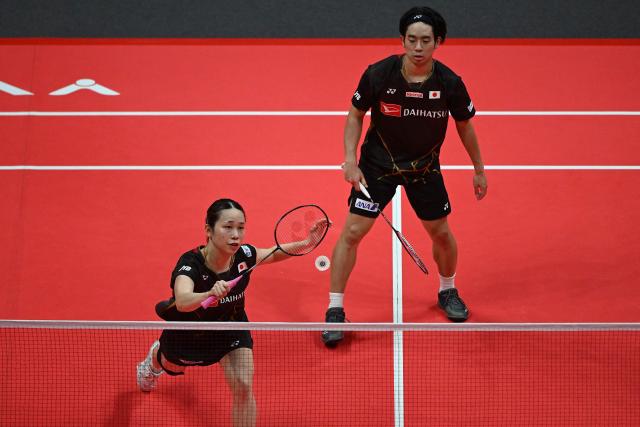Japan’s Hiroki Midorikawa (R) and Natsu Saito play a point during their mixed doubles semifinal match against China’s Feng Yan Zhe and Huang Dongping at the BWF Badminton World Tour Finals at the Hangzhou Olympic Sports Centre Gymnasium in Hangzhou, in eastern China's Zhejiang province on December 20, 2025. (Photo by Jade Gao / AFP)