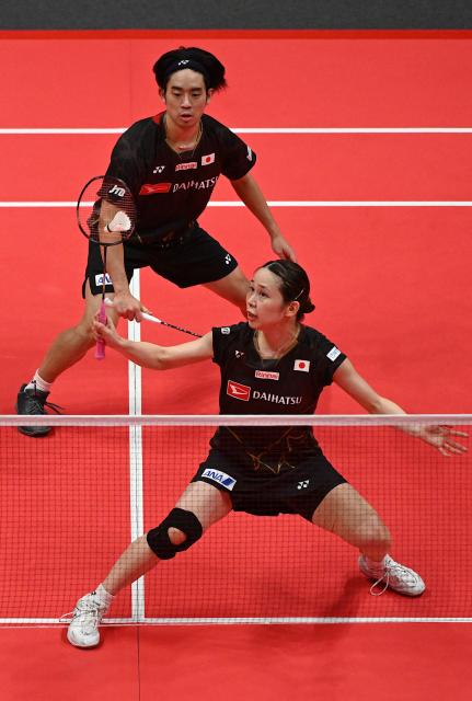 Japan’s Hiroki Midorikawa (top) and Natsu Saito play a point during their mixed doubles semifinal match against China’s Feng Yan Zhe and Huang Dongping at the BWF Badminton World Tour Finals at the Hangzhou Olympic Sports Centre Gymnasium in Hangzhou, in eastern China's Zhejiang province on December 20, 2025. (Photo by Jade Gao / AFP)