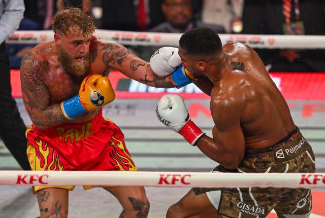 US boxer and influencer Jake Paul (L) and British boxer Anthony Joshua fight in a non-title heavyweight bout at the Kaseya Center in Miami, Florida on December 19, 2025. (Photo by Giorgio VIERA / AFP)