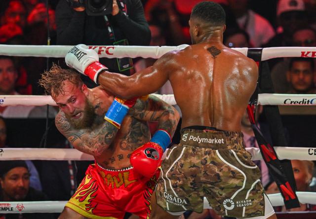 US boxer and influencer Jake Paul (L) and British boxer Anthony Joshua fight in a non-title heavyweight bout at the Kaseya Center in Miami, Florida on December 19, 2025. (Photo by Giorgio VIERA / AFP)
