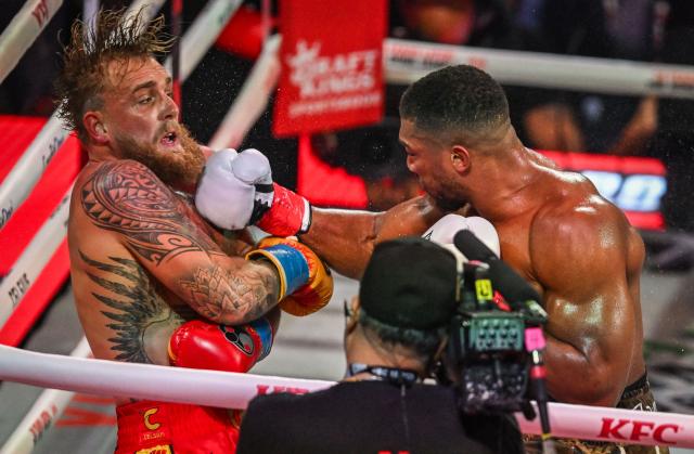 US boxer and influencer Jake Paul (L) and British boxer Anthony Joshua fight in a non-title heavyweight bout at the Kaseya Center in Miami, Florida on December 19, 2025. (Photo by Giorgio VIERA / AFP)