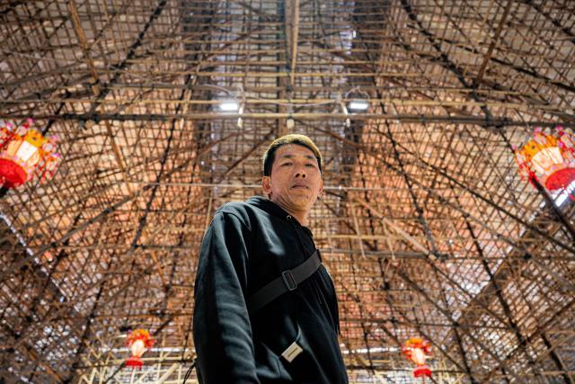 Lai Chi-ming, a bamboo scaffolding worker who co-planned the theater altar for Jiao Festival in Kam Tin, poses for a photo during the decennial Jiao Festival of Kam Tin in Hong Kong on December 18, 2025. Chanting villagers parade a giant effigy through the alleys of rural Hong Kong before setting it ablaze in a once-in-a-decade ceremony to ward off bad luck and appease their ancestors. Residents of Kam Tin decked out their northern corner of the city with towering flower boards and a vast bamboo stage for the Taoist Jiao festival which dates back over 300 years. (Photo by Leung Man Hei / AFP) / To go with 'HONG KONG-CHINA-CULTURE-TRADITION-RITUAL, REPORTAGE' by Tommy WANG
