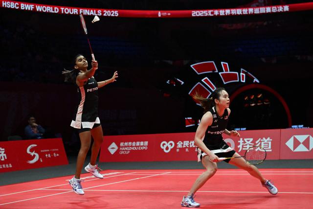Malaysia’s Pearly Tan and Thinaah Muralitharan (L) play a point during their women’s doubles semifinal match against Japan’s Yuki Fukushima and Mayu Matsumoto at the BWF Badminton World Tour Finals at the Hangzhou Olympic Sports Centre Gymnasium in Hangzhou, in eastern China's Zhejiang province on December 20, 2025. (Photo by Jade Gao / AFP)