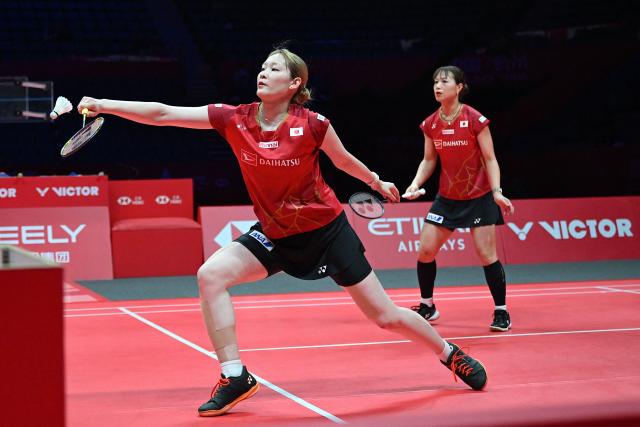 Japan’s Yuki Fukushima and Mayu Matsumoto (L) play a point during their women’s doubles semifinal match against Malaysia’s Pearly Tan and Thinaah Muralitharan at the BWF Badminton World Tour Finals at the Hangzhou Olympic Sports Centre Gymnasium in Hangzhou, in eastern China's Zhejiang province on December 20, 2025. (Photo by Jade Gao / AFP)