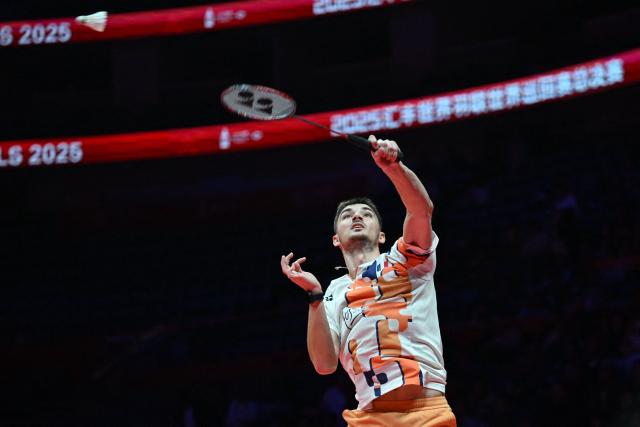 France’s Christo Popov hits a return to Japan’s Kodai Naraoka during their men’s singles semifinal match at the BWF Badminton World Tour Finals at the Hangzhou Olympic Sports Centre Gymnasium in Hangzhou, in eastern China's Zhejiang province on December 20, 2025. (Photo by Jade Gao / AFP)