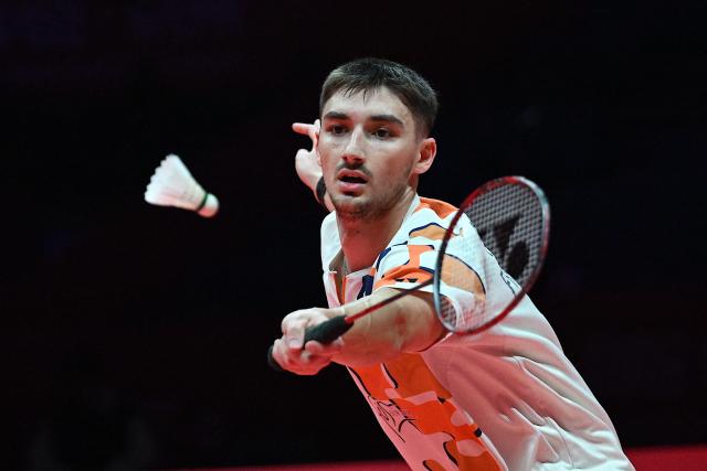 France’s Christo Popov hits a return to Japan’s Kodai Naraoka during their men’s singles semifinal match at the BWF Badminton World Tour Finals at the Hangzhou Olympic Sports Centre Gymnasium in Hangzhou, in eastern China's Zhejiang province on December 20, 2025. (Photo by Jade Gao / AFP)
