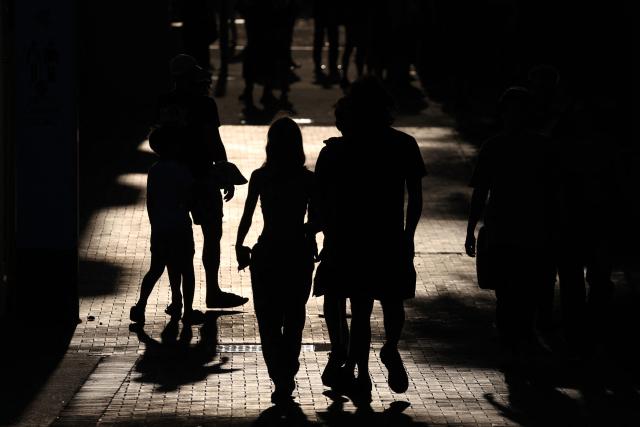 People walk towards the floral tribute memorial as mourners gather in memory of victims of a shooting at Bondi Beach, in Sydney on December 20, 2025. Father-and-son gunmen are accused of firing into crowds at a beachside Jewish festival on December 14, killing 15 in an attack authorities linked to "Islamic State ideology". (Photo by DAVID GRAY / AFP)
