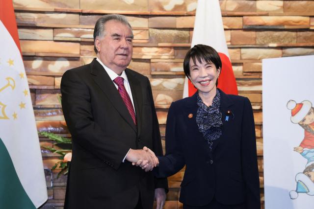 Japan's Prime Minister Sanae Takaichi (R) shakes hands with Tajikistan's President Emomali Rahmon ahead of their summit meeting, at the Prime Minister's Office in Tokyo on December 20, 2025. (Photo by JIJI Press / AFP) / Japan OUT