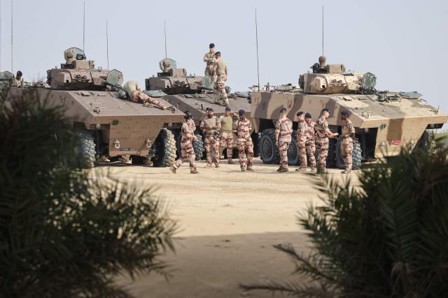 French soldiers from the 5th Tank Regiment stand next to infantry armoured vehicles during a training exercise at a military field in Zayed Military City, near Abu Dhabi, on December 20, 2025. (Photo by Ludovic MARIN / AFP)