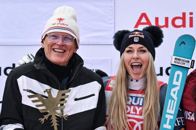 Third-placed US Lindsey Vonn (C-R) celebrates with her father Alan Kildow (C) and members of her team during the podium ceremony after competing in the women's downhill race part of the FIS Alpine Ski World Cup 2025-2026, in Val d'Isere, south western France, on December 20, 2025. (Photo by Jeff PACHOUD / AFP)