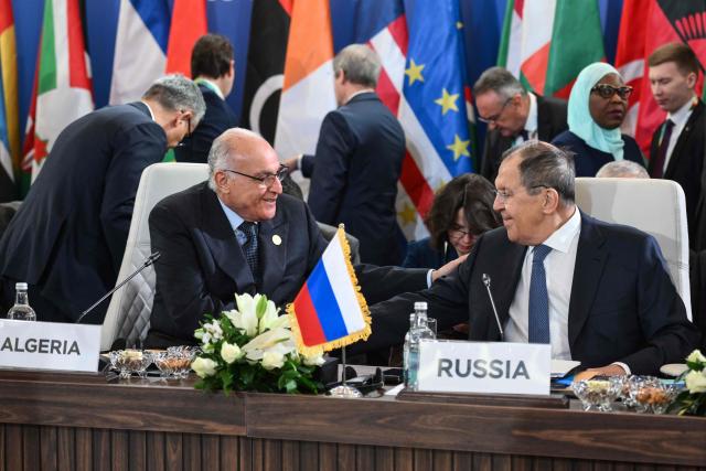 Russia's Foreign Minister Sergey Lavrov (R) chats with Algeria's Foreign Minister Ahmed Attaf during the second Ministerial Conference of the Russia-Africa Partnership Forum in Cairo on December 20, 2025. (Photo by Ahmed HASAN / AFP)