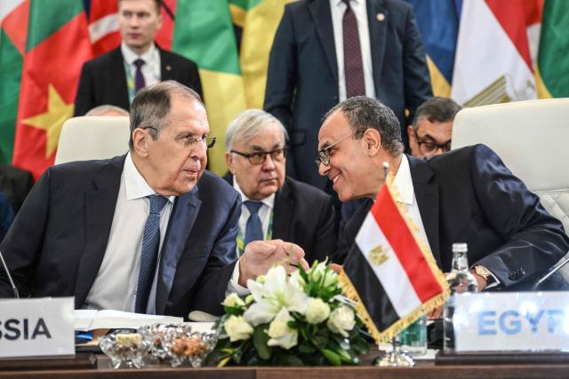 Russia's Foreign Minister Sergey Lavrov (L) and Egypt's Foreign Minister Badr Abdelatty chat during the second Ministerial Conference of the Russia-Africa Partnership Forum in Cairo on December 20, 2025. (Photo by Ahmed HASAN / AFP)