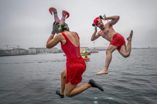 Disguised swimmers dive into Lake Geneva during the 87th "Coupe de Noel" (Christmas Cup) swimming race in Geneva on December 20, 2025. More than 4,200 participants took part in the traditional two-day event, a 120m-long swim off Geneva's banks into the 8.9 degrees Celsius water. (Photo by Fabrice COFFRINI / AFP)