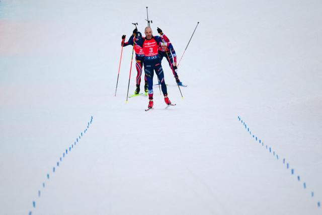 France's Eric Perrot (R), France's Emilien Jacquelin (C) and Norway's Johannes Dale-Skjevdal (L) ski to the finish line during the men's 12,5km pursuit event of the IBU Biathlon World Cup, in Le Grand Bornand, near Annecy, southeastern France, on December 20, 2025. (Photo by Olivier CHASSIGNOLE / AFP)