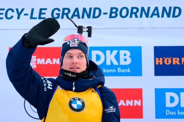 First placed Norway's Johan-Olav Botn celebrates on the podium of the men's 12,5km pursuit event of the IBU Biathlon World Cup, in Le Grand Bornand, near Annecy, southeastern France, on December 20, 2025. (Photo by Olivier CHASSIGNOLE / AFP)