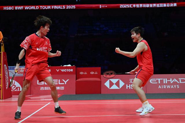 China’s Liang Weikeng and Wang Chang react after a point during their men’s doubles semifinal match against India’s Satwiksairaj Rankireddy and Chirag Shetty at the BWF Badminton World Tour Finals at the Hangzhou Olympic Sports Centre Gymnasium in Hangzhou, in eastern China's Zhejiang province on December 20, 2025. (Photo by Jade Gao / AFP)