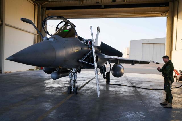 An Air Force pilot from 104 French Air Base prepares a French Rafale fighter jet to take off for a training exercise at the air base of Al Dhafra, near Abu Dhabi on December 20, 2025. (Photo by Ludovic MARIN / AFP)
