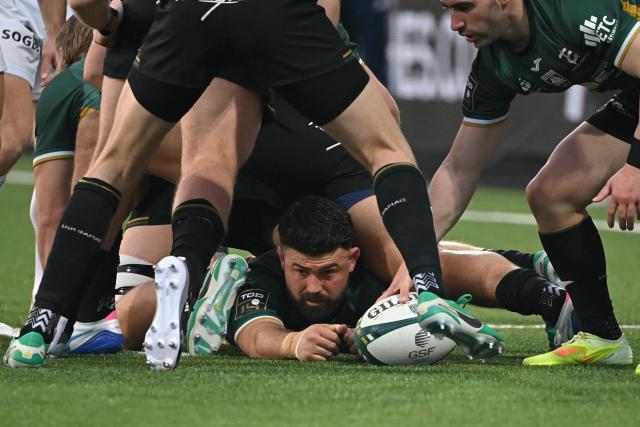 Montauban's French prop Thomas Bue (bottom, C) releases the ball while being tackled during the French Top14 rugby union match between US Montauban and Paloise Bearn Pyrenees (Pau) at Stade Sapiac in Montauban, south-western France on December 20, 2025. (Photo by Matthieu RONDEL / AFP)