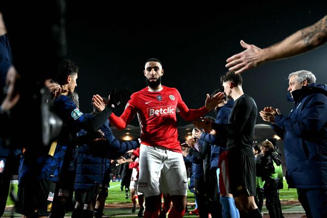 Lille’s players greet Lusitanos’ players at the end of the French Cup round of 64 football match between US Lusitanos Saint-Maur and Lille OSC (LOSC), at Dominique-Duvauchelle stadium, in Creteil, in the outskirts of Paris, on December 20, 2025. (Photo by Julie SEBADELHA / AFP)