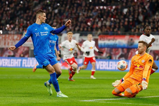Bayer Leverkusen's Czech forward #14 Patrik Schick (L) fails to score past Leipzig's Hungarian goalkeeper #01 Peter Gulacsi (R) during the German first division Bundesliga football match between RB Leipzig and Bayer 04 Leverkusen in Leipzig, eastern Germany, on December 20, 2025. (Photo by Odd ANDERSEN / AFP) / DFL REGULATIONS PROHIBIT ANY USE OF PHOTOGRAPHS AS IMAGE SEQUENCES AND/OR QUASI-VIDEO