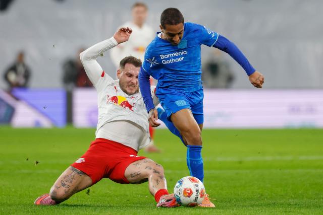 Bayer Leverkusen's Brazilian defender #13 Arthur (R) and Leipzig's German defender #22 David Raum vie for the ball during the German first division Bundesliga football match between RB Leipzig and Bayer 04 Leverkusen in Leipzig, eastern Germany, on December 20, 2025. (Photo by Odd ANDERSEN / AFP) / DFL REGULATIONS PROHIBIT ANY USE OF PHOTOGRAPHS AS IMAGE SEQUENCES AND/OR QUASI-VIDEO