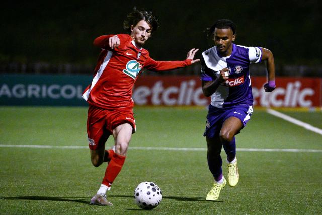 La Duchere’s French defender Mattheo Haon (L) fights for the ball with Toulouse’s French forward Yann Gboho (R) during the French Cup round of 64 football match between Lyon-La Duchere and Toulouse FC at Balmont stadium in Lyon, central France, on December 20, 2025. (Photo by ARNAUD FINISTRE / AFP)