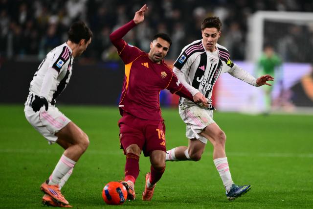 Roma's Turkish defender #19 Zeki Celik (C) and Juventus' Turkish forward #10 Kenan Yildiz (R) fight for the ball during the Italian Serie A football match between Juventus and AS Roma at the Allianz stadium in Turin, northern Italy, on December 20, 2025. (Photo by MARCO BERTORELLO / AFP)
