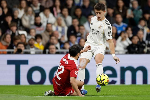 Sevilla's Chilean defender #12 Gabriel Suazo and Real Madrid's Turkish midfielder #15 Arda Guler fight for the ball during the Spanish league football match between Real Madrid CF and Sevilla FC at Santiago Bernabeu Stadium in Madrid on December 20, 2025. (Photo by Oscar DEL POZO / AFP)
