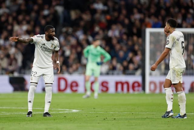 Real Madrid's German defender #22 Antonio Ruediger speaks to Real Madrid's English midfielder #05 Jude Bellingham during the Spanish league football match between Real Madrid CF and Sevilla FC at Santiago Bernabeu Stadium in Madrid on December 20, 2025. (Photo by Oscar DEL POZO / AFP)