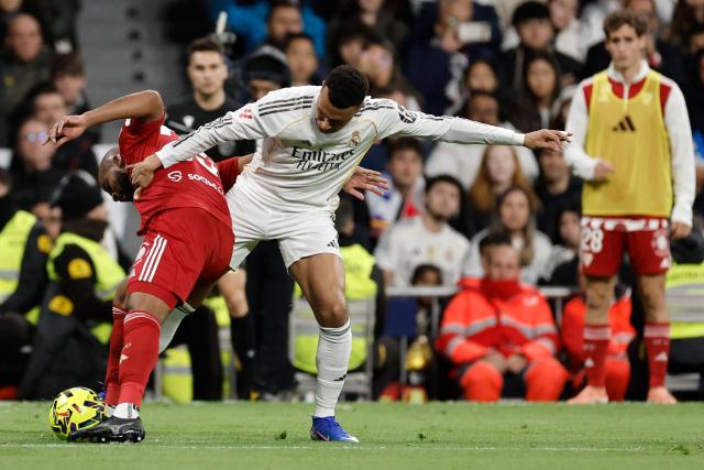 Sevilla's Brazilian defender #23 Marcao Teixeira (L) and Real Madrid's French forward #10 Kylian Mbappe fight for the ball during the Spanish league football match between Real Madrid CF and Sevilla FC at Santiago Bernabeu Stadium in Madrid on December 20, 2025. (Photo by Oscar DEL POZO / AFP)