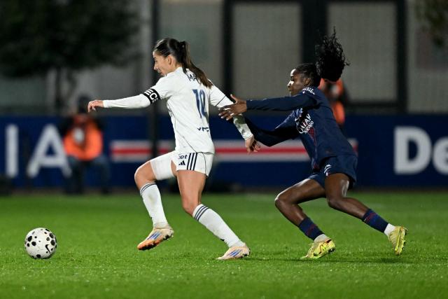 Paris FC’s French forward #10 Clara Mateo (L) fights for the ball with PSG’s French defender #02 Thiniba Samoura (R) during the French D1 women's football match between Paris Saint-Germain and Paris FC at Campus Paris Saint-Germain in Poissy, western of Paris on December 20, 2025. (Photo by Julie SEBADELHA / AFP)