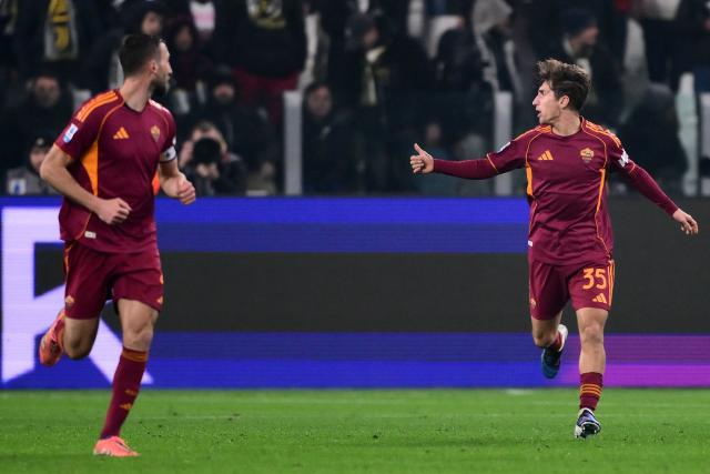 Roma's Italian midfielder #35 Tommaso Baldanzi (R) celebrates after scoring Roma's first goal during the Italian Serie A football match between Juventus and AS Roma at the Allianz stadium in Turin, northern Italy, on December 20, 2025. (Photo by MARCO BERTORELLO / AFP)