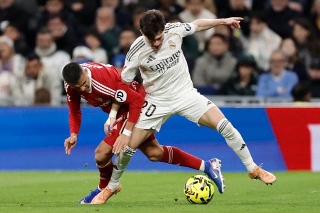 Sevilla's Chilean forward #10 Alexis Sanchez (L) and Real Madrid's Spanish defender #20 Francisco Garcia fight for the ball during the Spanish league football match between Real Madrid CF and Sevilla FC at Santiago Bernabeu Stadium in Madrid on December 20, 2025. (Photo by Oscar DEL POZO / AFP)