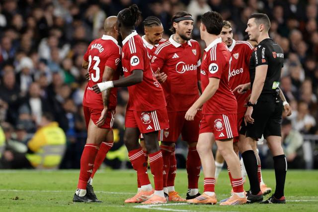 Sevilla's Brazilian defender #23 Marcao Teixeira (L) is sent off the pitch after receiving a red card from Spanish referee Muniz Ruiz during the Spanish league football match between Real Madrid CF and Sevilla FC at Santiago Bernabeu Stadium in Madrid on December 20, 2025. (Photo by Oscar DEL POZO / AFP)