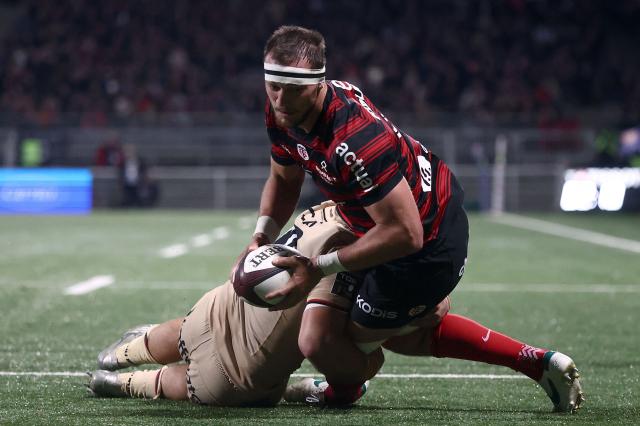 Toulouse's French number eight Alexandre Roumat jumps to score a try during the French Top14 rugby union match between Lyon Olympique Universitaire Rugby and Stade Toulousain Rugby (Toulouse) at the Gerland Stadium in Lyon, central-eastern France on December 20, 2025. (Photo by Alex MARTIN / AFP)