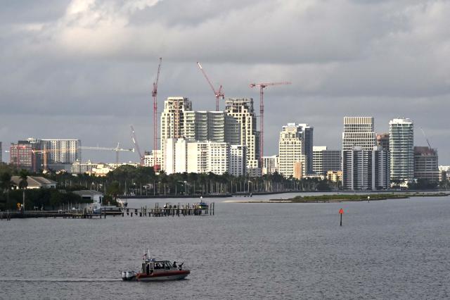 A patrol boat is seen as the motorcade with US President Donald Trump passes over a bridge on Presidents Trumps way back to Mar-a-Lago club in Palm Beach, Florida on December 20, 2025. (Photo by ANDREW CABALLERO-REYNOLDS / AFP)