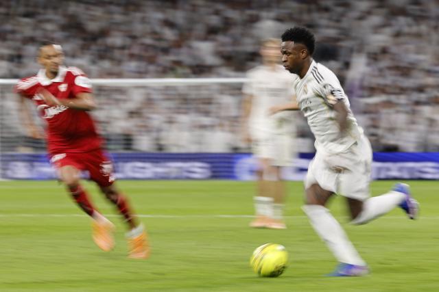 Real Madrid's Brazilian forward #07 Vinicius Junior (R) is challenged by Sevilla's Swiss midfielder #20 Djibril Sow during the Spanish league football match between Real Madrid CF and Sevilla FC at Santiago Bernabeu Stadium in Madrid on December 20, 2025. (Photo by Oscar DEL POZO / AFP)