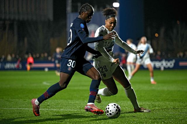 PSG's Congolese forward #30 Merveille Kanjinga (L) fights for the ball with Paris FC’s American defender #29 Deja Davis during the French D1 women's football match between Paris Saint-Germain and Paris FC at Campus Paris Saint-Germain in Poissy, western of Paris on December 20, 2025. (Photo by Julie SEBADELHA / AFP)