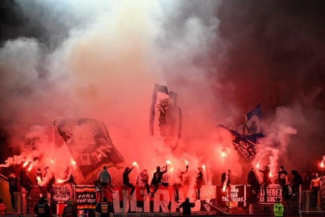 Paris Saint-Germain's supporters light flares as they cheer their team on from the stands during the French Cup round of 64 football match between Fontenay-le-Comte and Paris Saint-Germain (PSG) at La Beaujoire stadium in Nantes, western France, on December 20, 2025. (Photo by Sebastien Salom-Gomis / AFP)