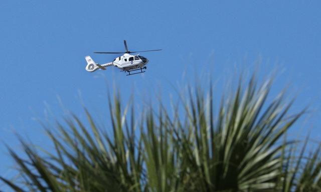 A NASA Airbus H135 security helicopter patrols above the Neil A. Armstrong Operations and Checkout Building during the Artemis II astronauts Countdown Demonstration Test at the Kennedy Space Center in Cape Canaveral, Florida on December 20, 2025. Crew members Jeremy Hansen, a Mission Specialist of Canadian Space Agency, NASA astronaut and Artemis II pilot Victor Glover, NASA astronaut and Artemis II Commander Reid Wiseman and NASA astronaut and Artemis II Mission Specialist Christina Koch went through an exercise designed to test launch-day procedures. It was a dress rehearsal of what will happen on launch day, which is currently targeted for no earlier than February 1, 2026. (Photo by Gregg Newton / AFP)