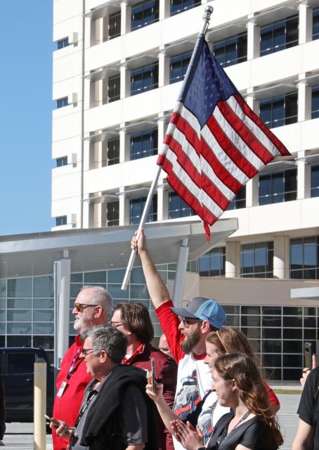 NASA employees cheer on the Artemis II lunar mission astronauts outside the Neil A. Armstrong Operations and Checkout Building during their Countdown Demonstration Test at the Kennedy Space Center in Cape Canaveral, Florida on December 20, 2025. The flight crew is comprised of Canadian Space Agency astronaut and Artemis II Mission Specialist Jeremy Hansen, NASA astronaut and Artemis II pilot Victor Glover, NASA astronaut and Artemis II Commander Reid Wiseman and NASA astronaut and Artemis II Mission Specialist Christina Koch. Designed to test launch-day procedures, the test is a dress rehearsal of what will happen on launch day, which is currently targeted for no earlier than February 1, 2026. (Photo by Gregg Newton / AFP)