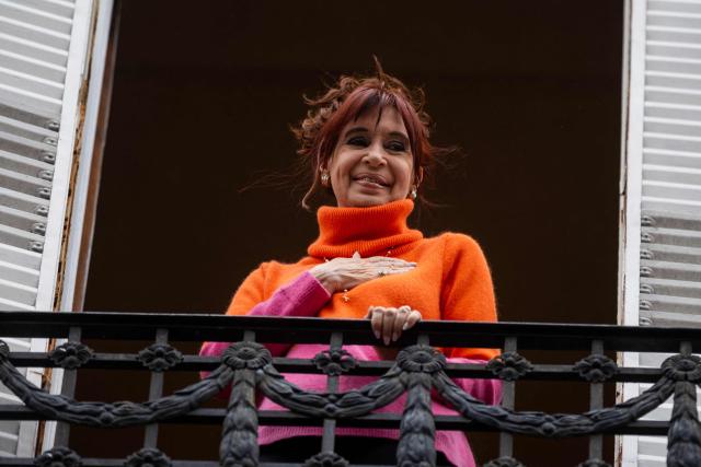 (FILES) Former Argentine President Cristina Fernandez de Kirchner greets cab drivers that gathered asking for her freedom from the balcony of her residence where she is serving house arrest in Buenos Aires on August 17, 2025. Cristina Kirchner was admitted to a hospital in Buenos Aires on December 20, 2025 for medical tests following abdominal pain, her press team said in a statement. (Photo by TOMAS CUESTA / AFP)