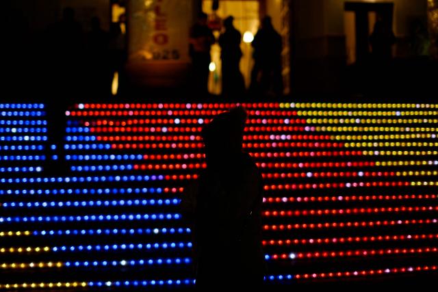 A woman stands in front of traditional Christmas lights at the Monserrate Mountain in Bogota on December 20, 2025. (Photo by Pablo VERA / AFP)