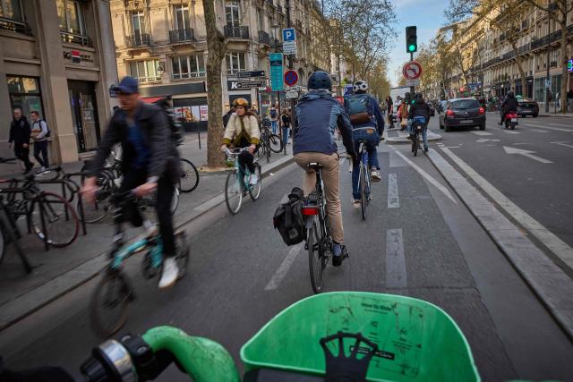 (FILES) Commuters ride their bikes in a cycle lane along Boulevard de Sebastopol, in central Paris on April 4, 2025. After picking up speed from 2020 onward, the construction of the cycling network in the Île-de-France region has hit the brakes due to budget pressures on the départements, which partly fund these large-scale projects. (Photo by Kiran RIDLEY / AFP)