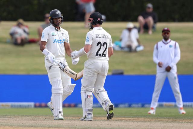 New Zealand’s Rachin Ravindra (L) and Kane Williamson touch bats during day four of the 3rd international Test cricket match between New Zealand and West Indies at Bay Oval in Mount Maunganui on December 21, 2025. (Photo by Michael Bradley / AFP)