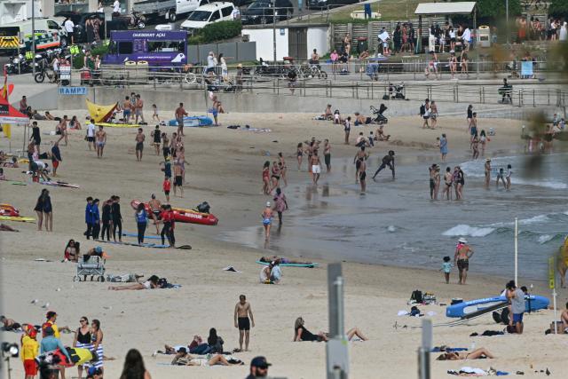People are seen at Bondi Beach ahead of a memorial for the victims of a shooting in Sydney on December 21, 2025. (Photo by Saeed KHAN / AFP)
