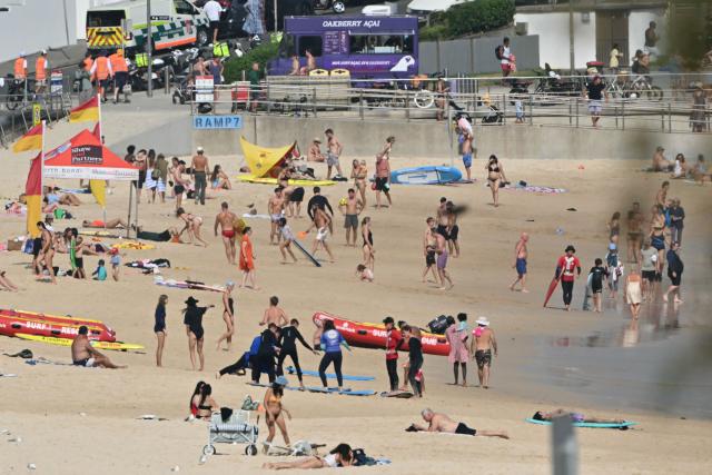 People are seen at Bondi Beach ahead of a memorial for the victims of a shooting in Sydney on December 21, 2025. (Photo by Saeed KHAN / AFP)